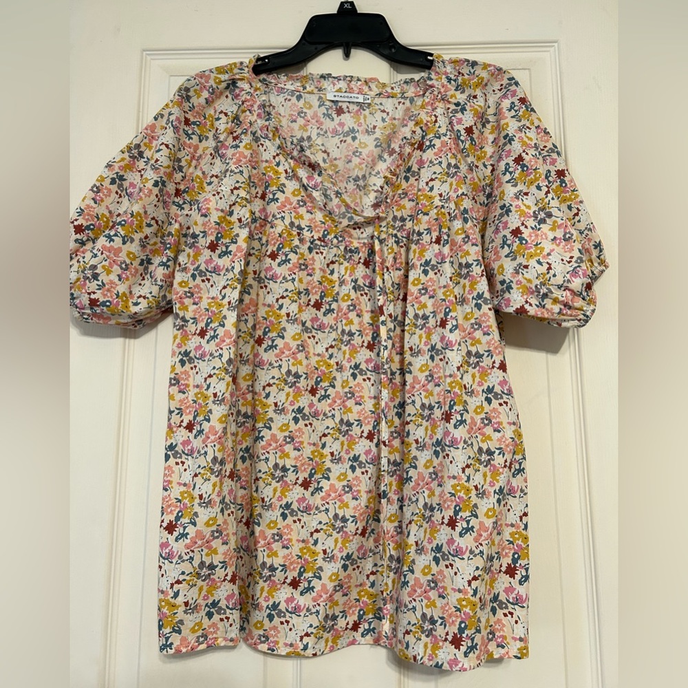 Floral blouse with tie at neck. Elastic around sleeves. Size M